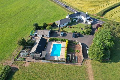 an aerial view of a house with a swimming pool at Bournestream in Withycombe