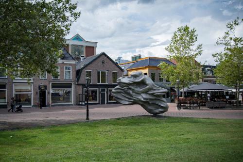 a metal sculpture of a woman on a city street at City Hotel de Jonge in Assen