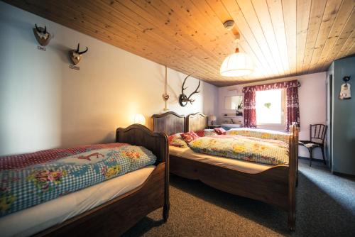 a bedroom with two beds and a window at Berghotel Schynige Platte in Wilderswil