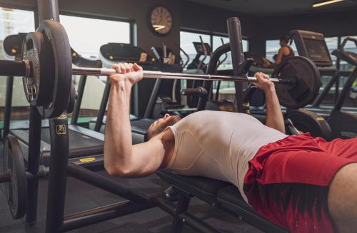 a man lifting a barbell in a gym at Ramada Plaza By Wyndham Istanbul City Center in Istanbul