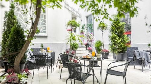 un patio esterno con tavoli, sedie e piante in vaso di Apartamenty Platinia - komfortowe noclegi Kraków Stare Miasto a Cracovia