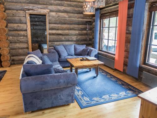 a living room with blue couches and a table at Holiday Home Tortone by Interhome in Ruka