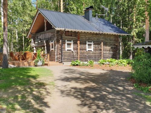 a log cabin with a driveway in front of it at Holiday Home Matruusin majakka by Interhome in Onkamo