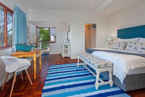 a bedroom with a bed and a table and a desk at 6 Stemmet Lodge in Hermanus