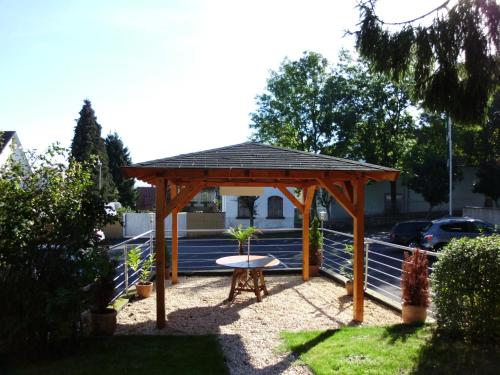 a wooden gazebo with a table in a yard at Hotel-Restaurant Zum Schwalbennest in Alsfeld