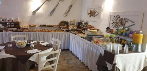 un ristorante con due tavoli e un bancone con cibo di Hotel Canne al Vento a Santa Teresa di Gallura