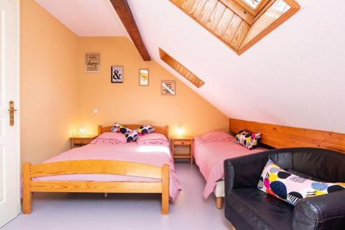 a attic bedroom with two beds and a couch at Maison 8 personnes au coeur de la vallée du Louron in Loudenvielle