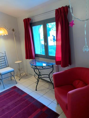 a living room with a red couch and a glass table at La Meyssonnié in Damiatte