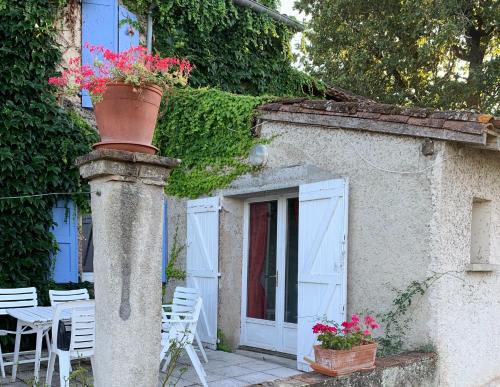 un bâtiment avec un pot de fleurs sur un poteau dans l'établissement La Meyssonnié, à Damiatte