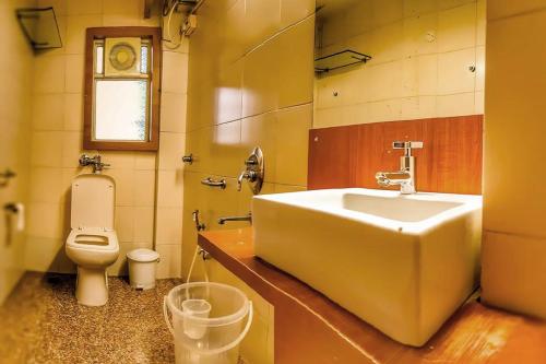 La salle de bains est pourvue d'un lavabo et de toilettes. dans l'établissement Hotel Samraj, à Mumbai