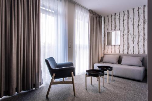 a living room with a couch and a chair at Pokoje4you in Koszalin