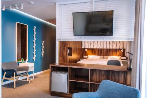 a bedroom with a bed and a television on a wall at Pokoje4you in Koszalin