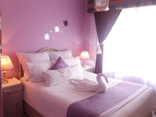 um quarto com uma cama com um cisne em Reemaros Guest House em Margate