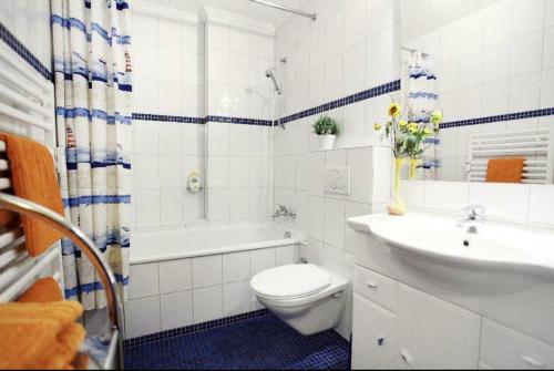 a white bathroom with a toilet and a sink at Stadtapartment in Lübeck