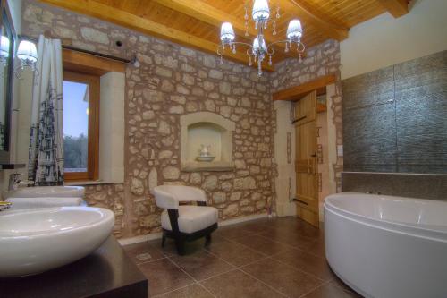 a stone bathroom with a tub and a sink at Green Paradise Villa in Margarítai