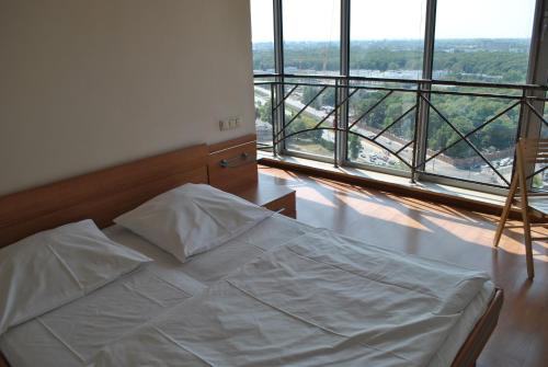 białe łóżko w pokoju z dużym oknem w obiekcie Warsaw Apartments Werset w Warszawie