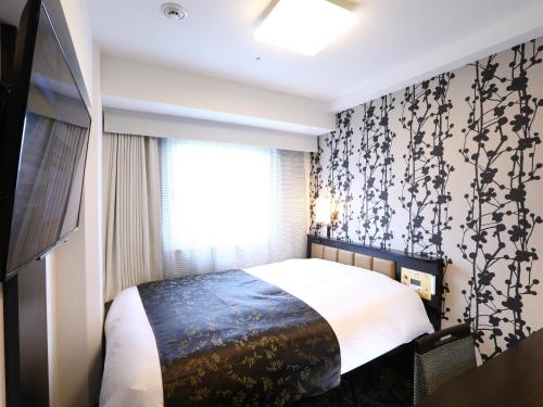 a bedroom with a bed with a black and white wallpaper at APA Hotel Ayase Ekimae in Tokyo