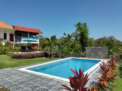 a swimming pool in the backyard of a house at The Pande Hill Homestay in Uluwatu