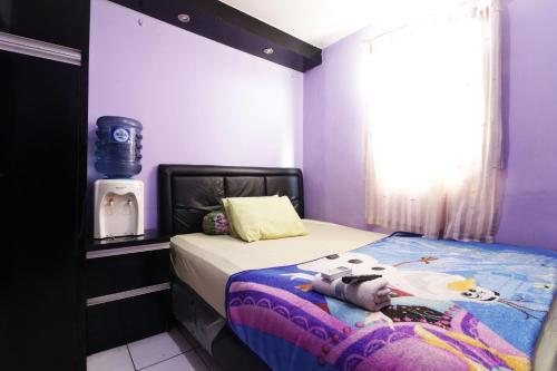 um pequeno quarto com uma cama com paredes roxas em Dinda Apartment Tangerang at Apartment Modernland em Kandang-besar