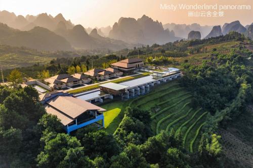 an aerial view of a resort with mountains in the background at Misty Wonderland ,Yangshuo Xingping in Yangshuo