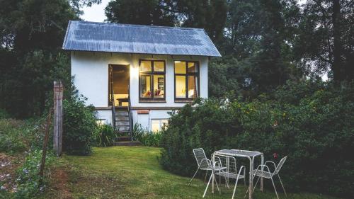 a small house with a table and chairs in the yard at The Knoll Historic Guest Farm in Hilton