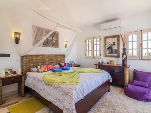 a bedroom with a large bed and a purple chair at Holiday Home Roberts by Interhome in Albufeira