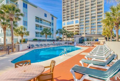a swimming pool with lounge chairs and a hotel at 2Br Penthouse in the Ocean Forest Plaza in Myrtle Beach