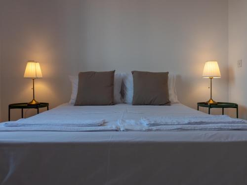 a large white bed with two lamps on both sides at KINGS SQUARE Holiday Apartments in Polis Chrysochous