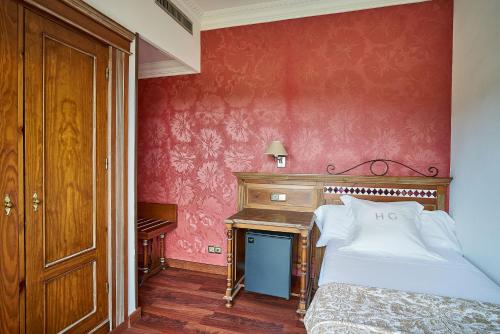 a bedroom with a bed and a wooden desk at Crisol Guadalupe in Granada
