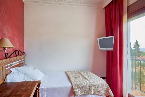 a hotel room with a bed and a window at Crisol Guadalupe in Granada