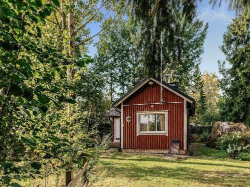 a small red cabin in the middle of a yard at Holiday Home C by Interhome in Porvoo