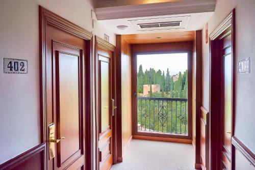 a hallway with doors and a window with a view at Crisol Guadalupe in Granada