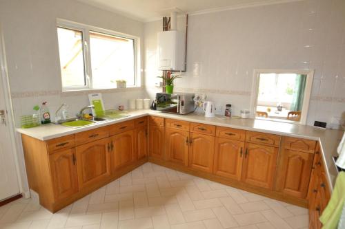 uma cozinha com armários de madeira, um lavatório e uma janela em Long Ledge em Bembridge