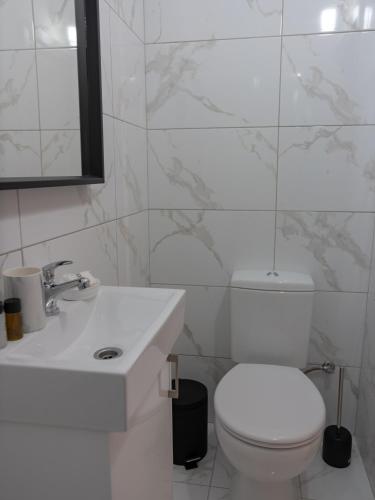 a white bathroom with a toilet and a sink at KINGS SQUARE Holiday Apartments in Polis Chrysochous