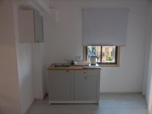 a small kitchen with a sink and a window at KINGS SQUARE Holiday Apartments in Polis Chrysochous