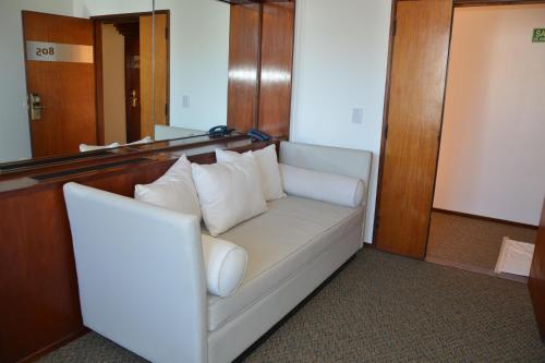 a white couch in a room with a mirror at Hotel de la Cañada in Cordoba