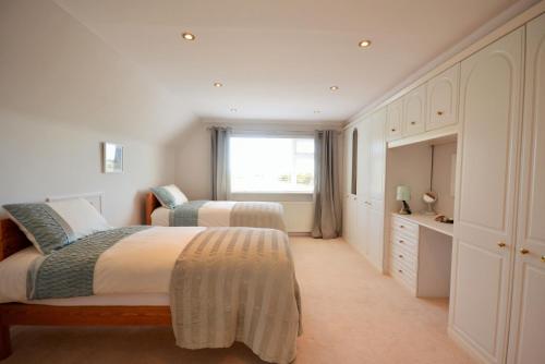 um quarto com 2 camas e uma janela em Long Ledge em Bembridge