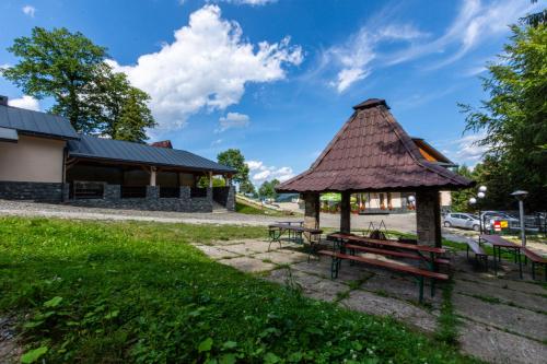 einem Pavillon mit einem Picknicktisch vor einem Gebäude in der Unterkunft Kompleks Pilsko-Jontek in Korbielów