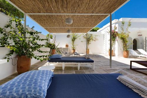 una camera con letto blu su un patio di Masseria Villa by Perle di Puglia a Torre Specchia Ruggeri