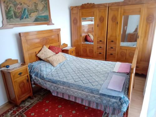 a small bedroom with a bed and wooden cabinets at Riverside Villa Matka in Skopje