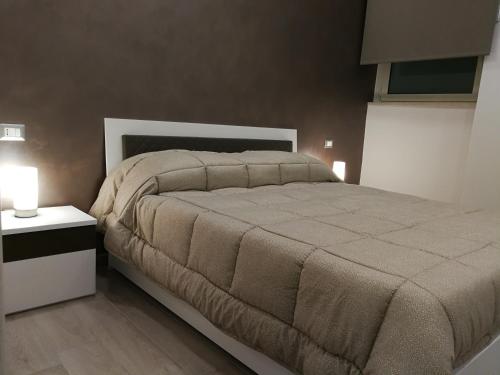 ein Schlafzimmer mit einem großen Bett und einem Nachttisch mit zwei Leuchten in der Unterkunft B&B Sweet Home in Grumo Appula