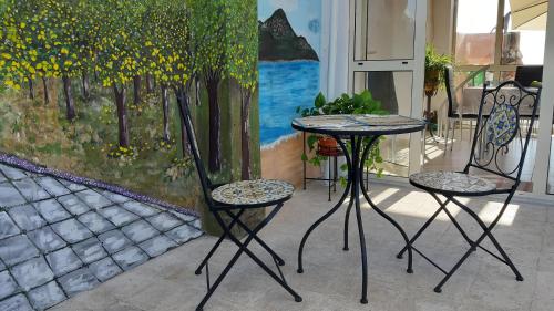 deux chaises et une table devant un tableau dans l'établissement B&B La Giara, à Piedimonte Etneo