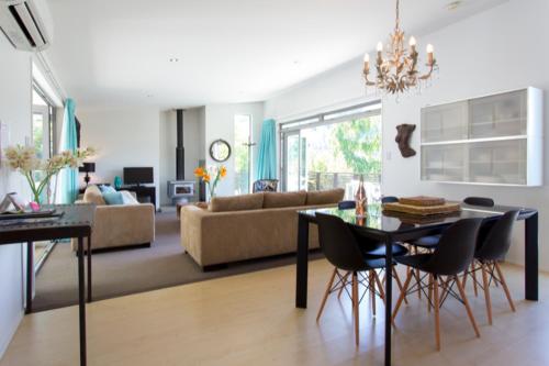 a living room with a table and chairs and a couch at Treehouse Spa Escape - Private Spa Pool in Queenstown