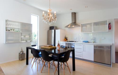 a kitchen with a table and chairs and a refrigerator at Treehouse Spa Escape - Private Spa Pool in Queenstown