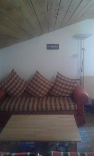 a living room with a couch with pillows on it at Rossruckhof in Rohrberg