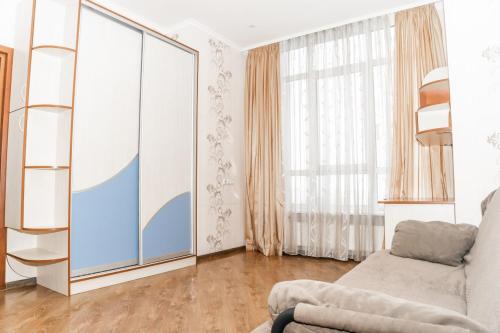 - un salon avec un canapé et une grande fenêtre dans l'établissement Fransuaza Apartments, à Odessa
