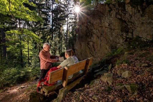 a man and a woman sitting on a bench at Familie Hotel Kameleon in Olsberg