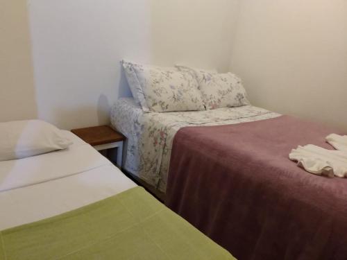 a small room with two beds and a pillow at Casa de Temporada in Itaúnas