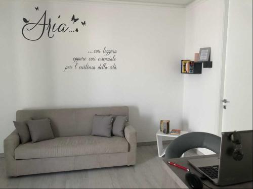 ein Wohnzimmer mit einem Sofa und einem Laptop an der Wand in der Unterkunft I Quattro Elementi in Marina di Mancaversa