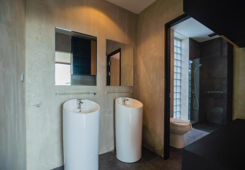 a bathroom with two sinks and a toilet at The Woods Natural Park Resort Phuket in Kamala Beach